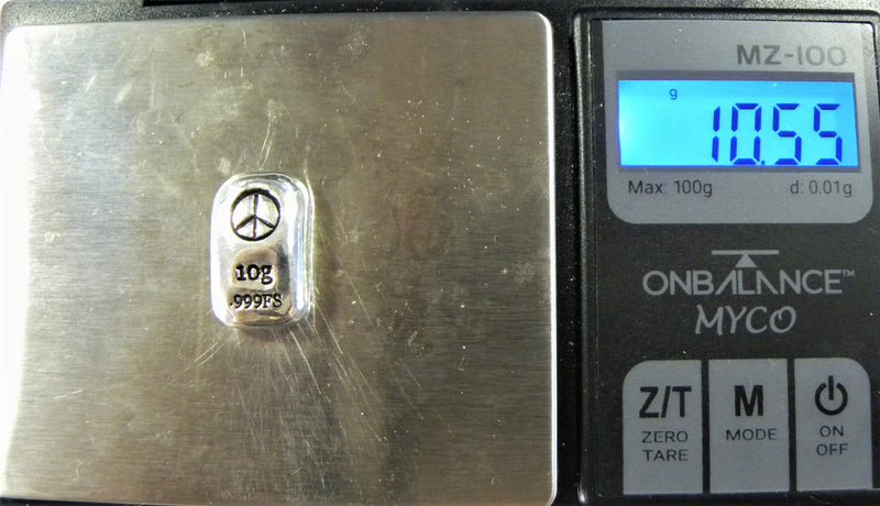 Distant view of a shiny 10g silver (999FS) rectangular bar, featuring a stamped Peace Symbol and 10g 999FS stamped below. The bar is placed  vertically on a digital weight scale.