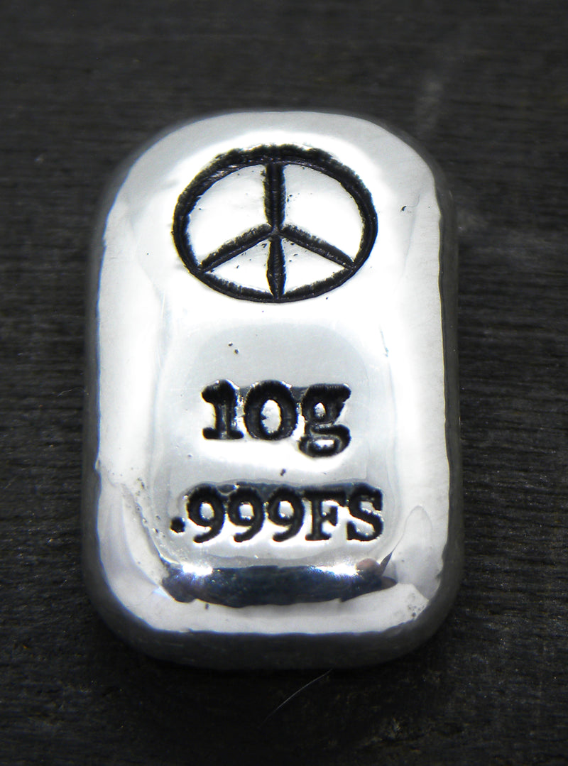 Close-up of a 10-gram 999 fine silver rectangular bar with a polished, reflective surface. The Peace Symbol stamp is stamped on the top half of the bar and 10g 999FS on the bottom half. The bar is positioned vertically.